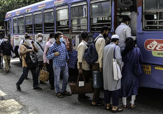 6月9日，人们在印度孟买的公共汽车站乘车。 新华社 图